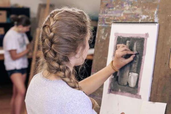 Student using charcoal for a still-life drawing