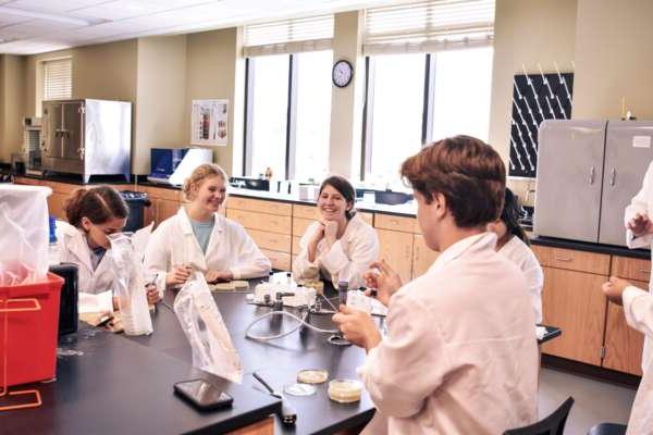 Students in lab coats with petri dishes